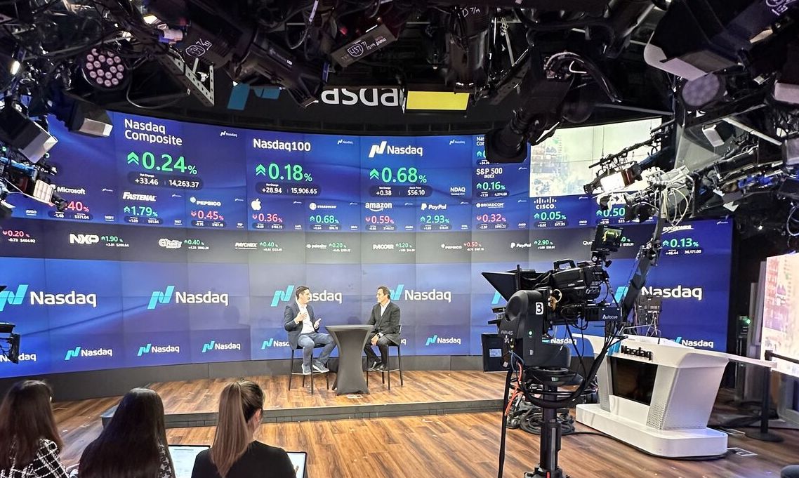 Night Vision 2024 trends - Photo of Live interview on stage with Nasdaq on background screens.