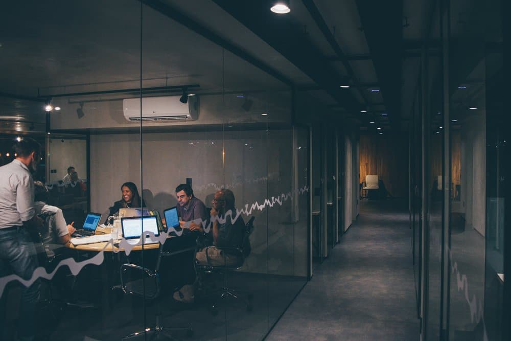 Employees working together in a glass conference room