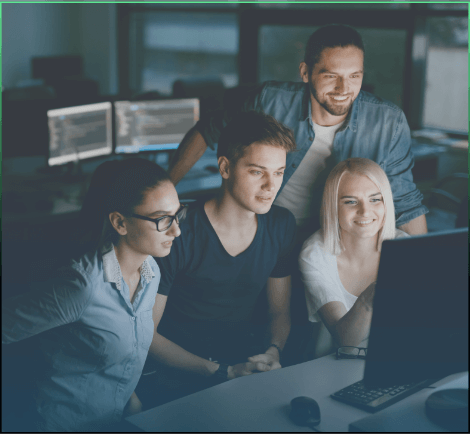 four people gathered around a computer screen