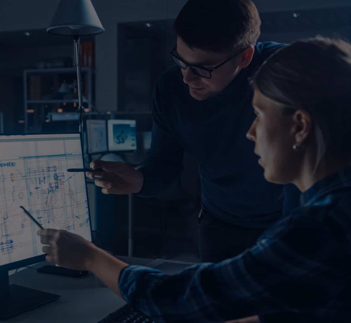 two people pointing to a desktop computer screen