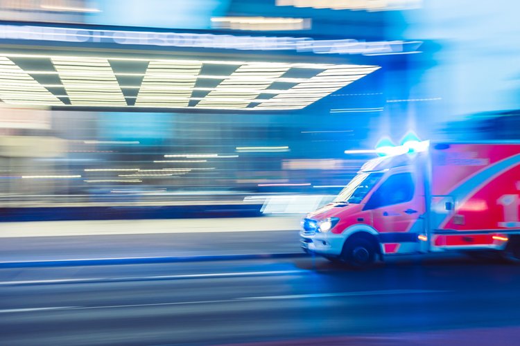 Ambulance speeding by a blurred building